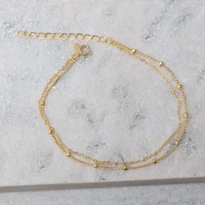 TORNOZELEIRA CORRENTE DUPLA E COM BOLINHA BANHO OURO 18K