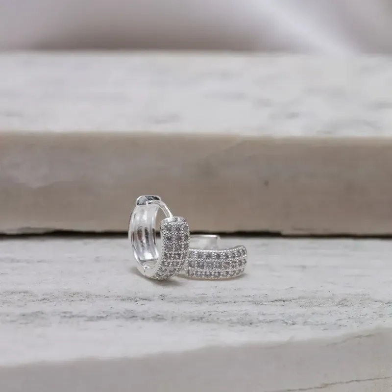 BRINCO ARGOLA CRAVEJADA COM ZIRCÔNIAS TRIPLAS BANHO PRATA