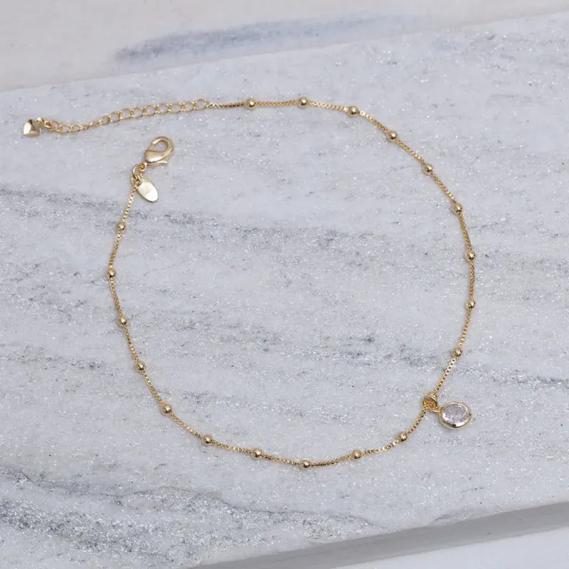TORNOZELEIRA BOLINHAS COM PONTO DE LUZ BANHO OURO 18K