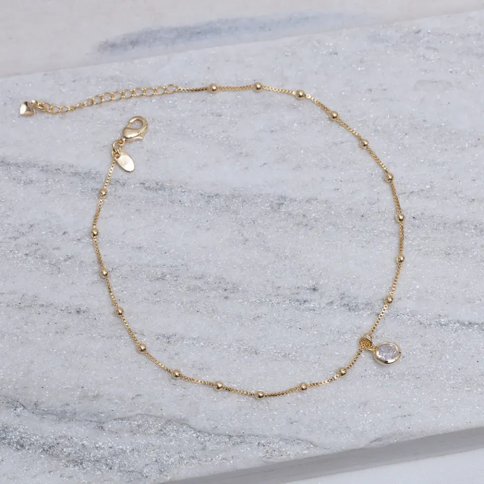 TORNOZELEIRA BOLINHAS COM PONTO DE LUZ BANHO OURO 18K