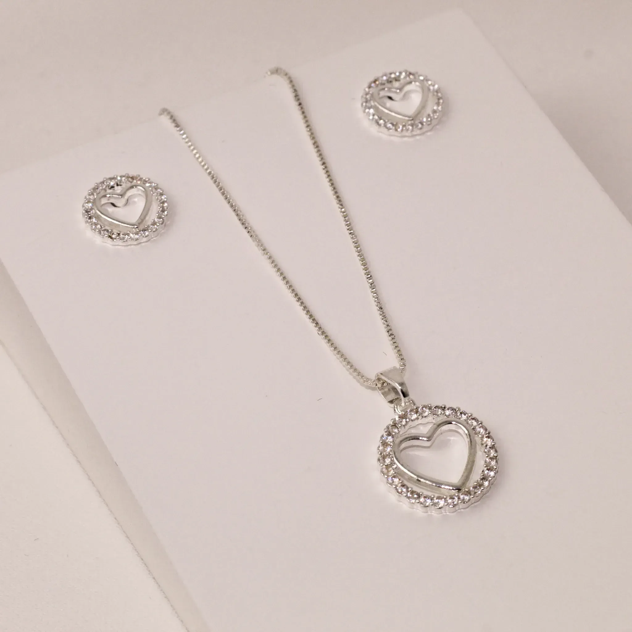CONJUNTO CORAÇÃO CRAVEJADO COM ZIRCÔNIAS CRISTAIS VAZADO BANHO PRATA