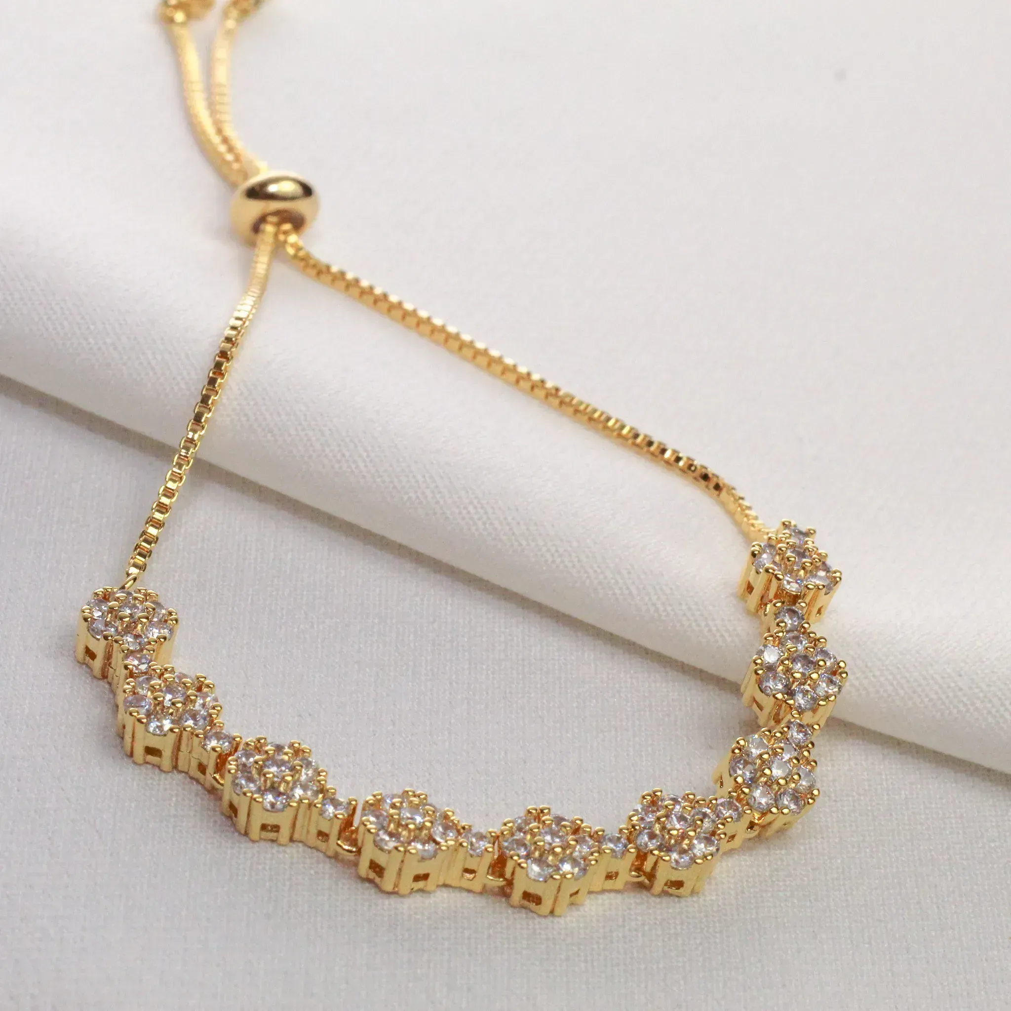 PULSEIRA FLOR CRAVEJADA COM ZIRCÔNIAS CRISTAIS FECHO GRAVATINHA BANHO OURO 18K
