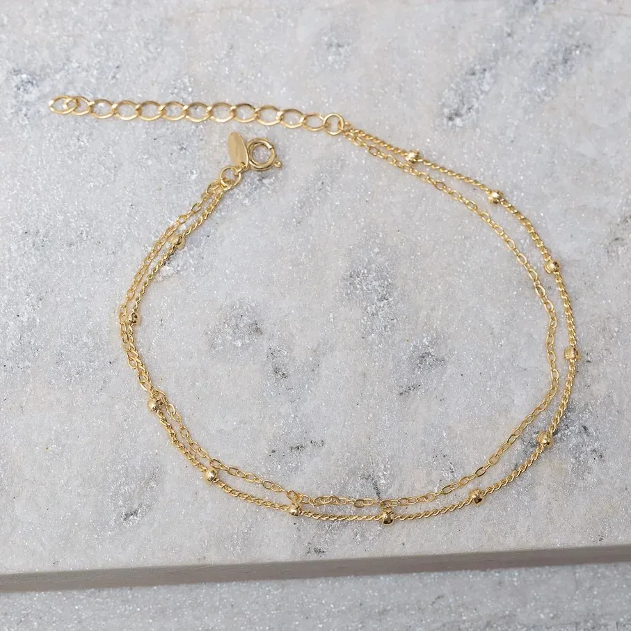 TORNOZELEIRA CORRENTE DUPLA E COM BOLINHA BANHO OURO 18K