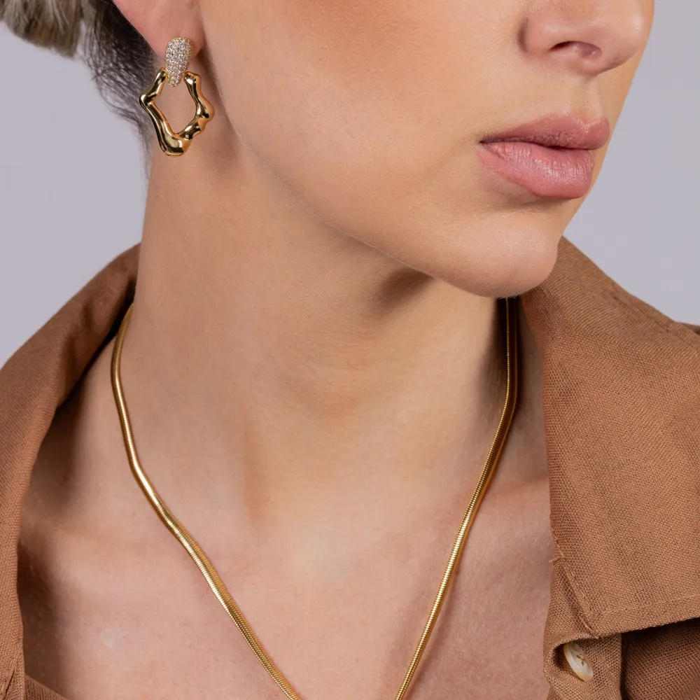 BRINCO ORGÂNICO COM BASE CRAVEJADA BANHO OURO 18K
