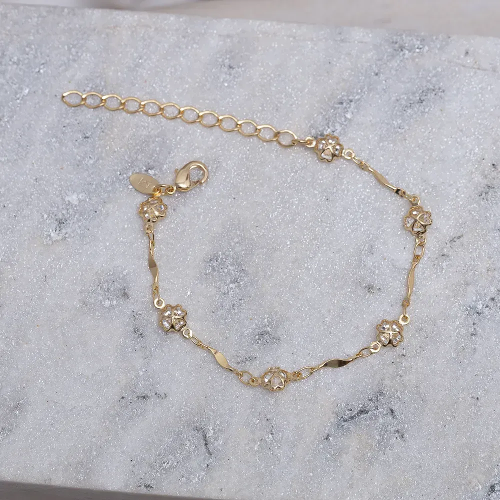 PULSEIRA TORCIDA COM TREVINHOS CRISTAIS BANHO OURO 18K